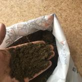 почвогрунт на ладони, на фоне мешка