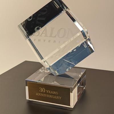 Статуэтка из оптического стекла в форме куба, поставленная на один из ее углов на постаменте.  Основание сувенира может быть выполнено из стекла, металла, дерева, камня по вашему желанию. С помощью различных техник гравировки, можно нанести практически любое изображение или надпись.  Подобная форма идеально подойдет для любого мероприятия, а также в качестве индивидуальной награды или предмета корпоративного стиля. 